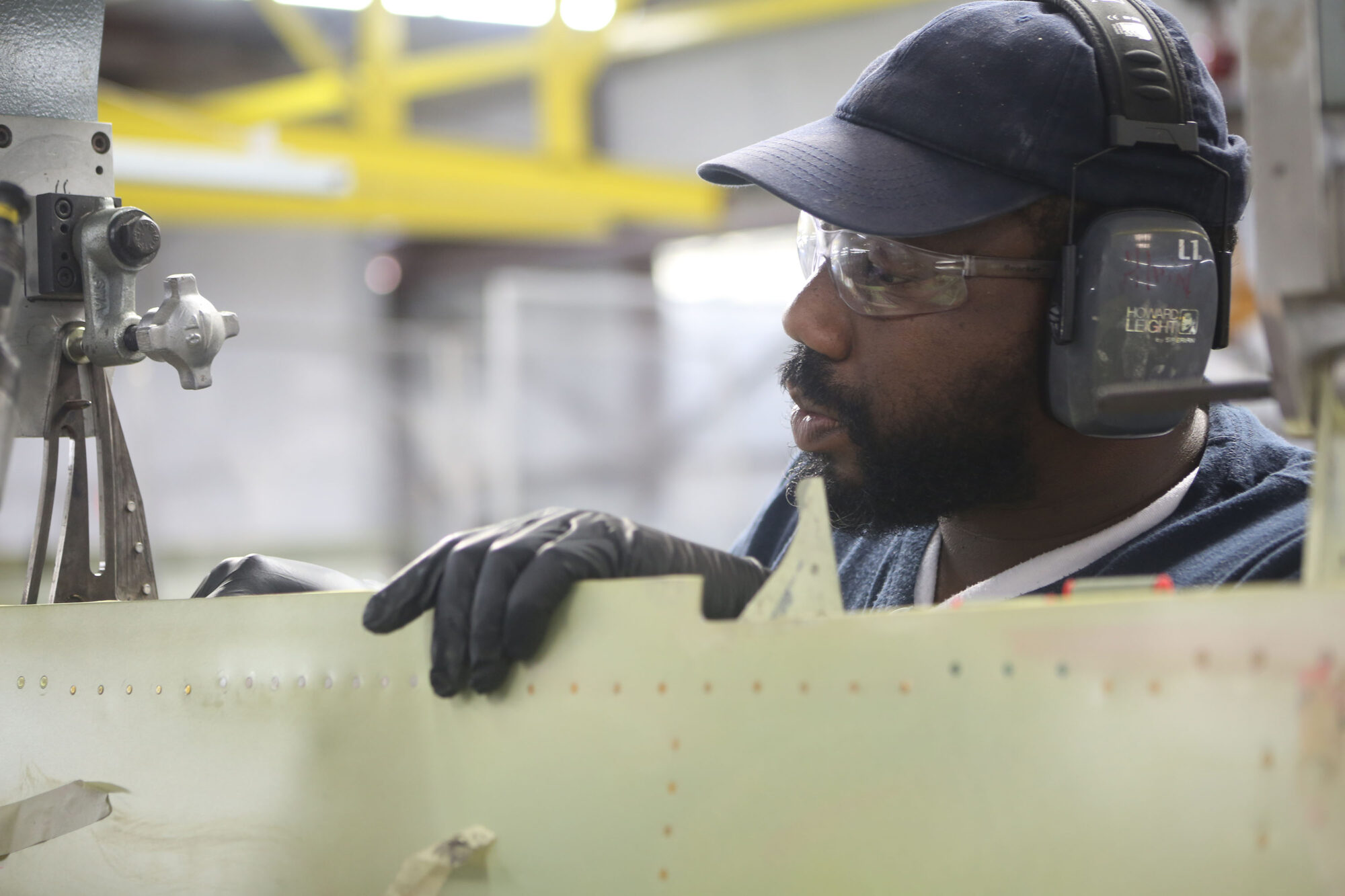 Piper Aircraft employee wearing goggles and working in a shop