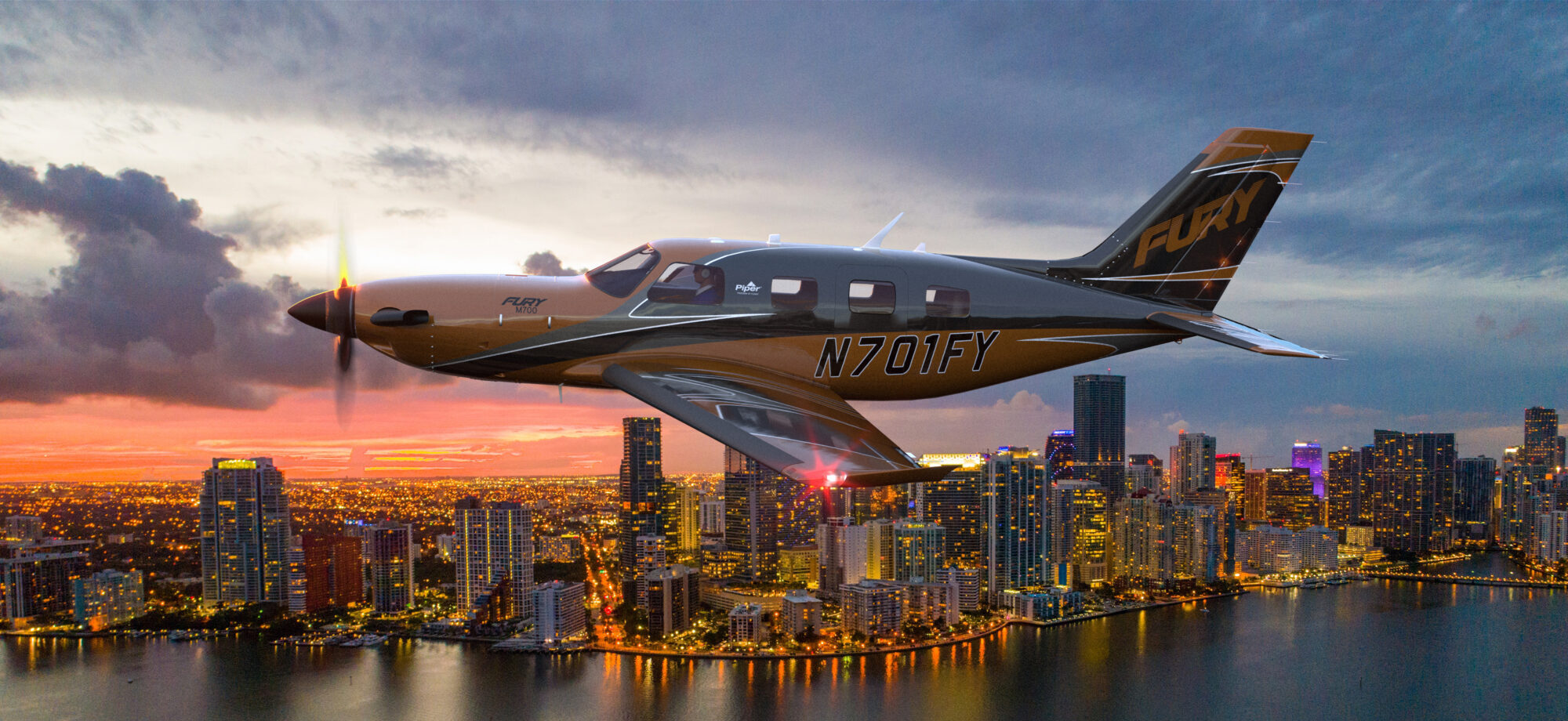 A Plane flying across the water with a city in the background.